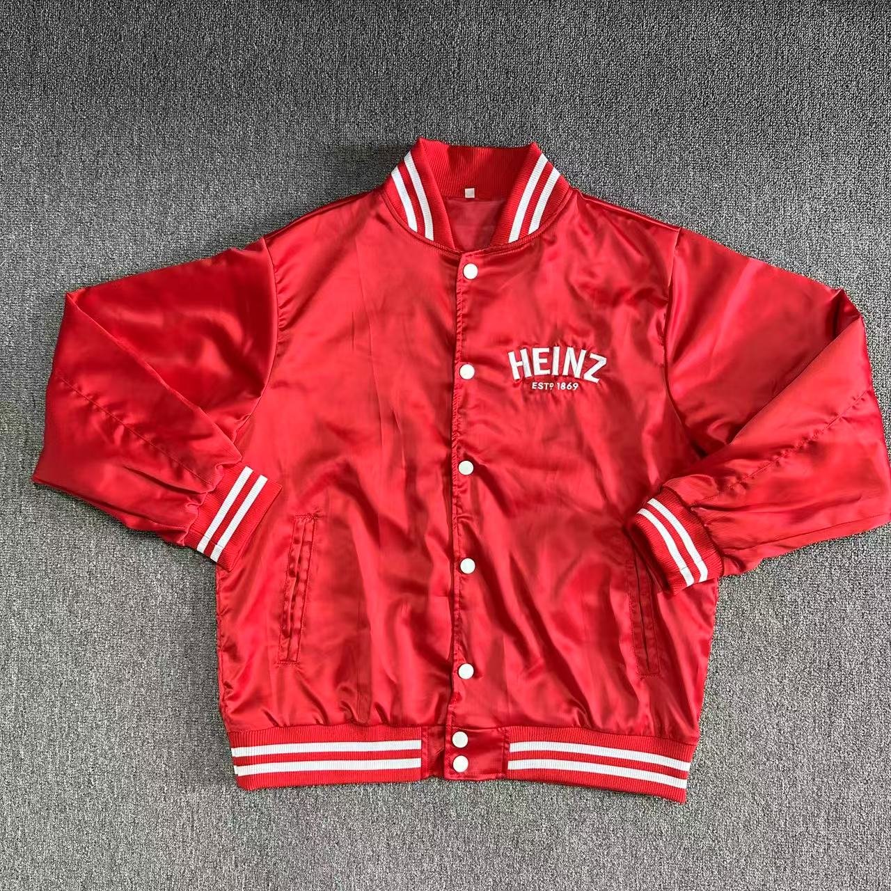 Red varsity style jacket with white stripes on neck, wrist cuffs, and waist band.